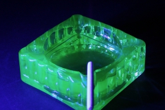 Vaseline/Uraniium glass ashtray with candy cigarette lit by black light